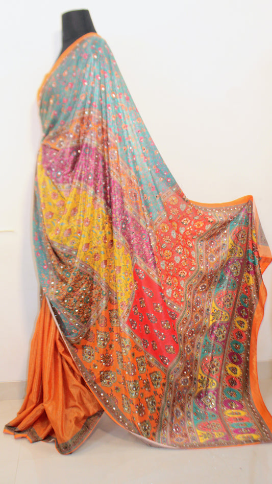 Goldfish orange Chinon silk saree with mirror-detailed pallu and crisp pleats—capturing festive shimmer and graceful movement.