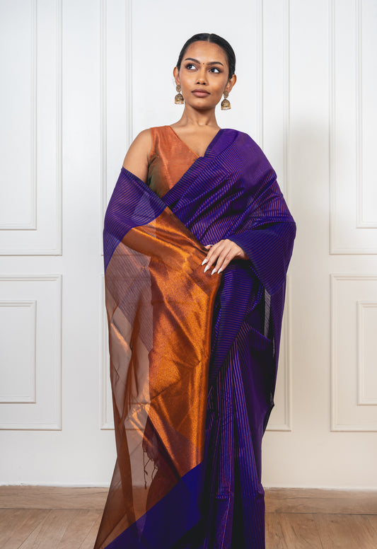 Blue Maheshwari cotton silk saree with copper zari pallu and crisp pleats—capturing regal contrast and woven richness.