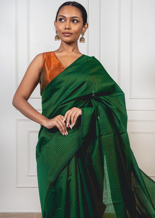 Green Maheshwari cotton silk saree with copper zari pallu and crisp pleats—capturing regal contrast and woven finesse