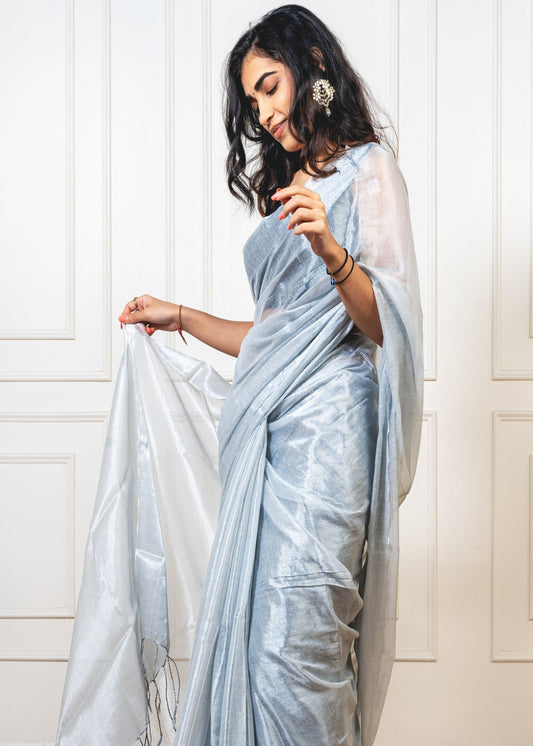 Moonlight silver tissue silk saree with flowing pallu and crisp pleats—capturing celestial glow and refined movement