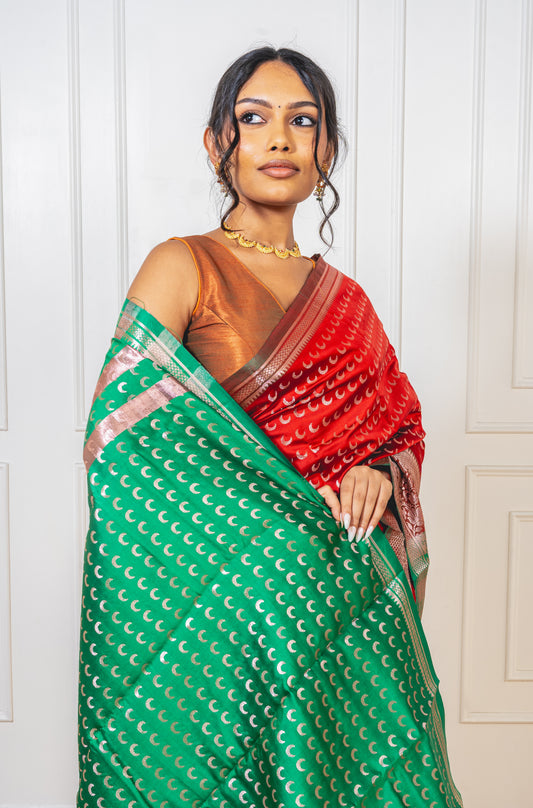 Close-up of crescent butta motifs on red saree—highlighting intricate weaving and lunar elegance.