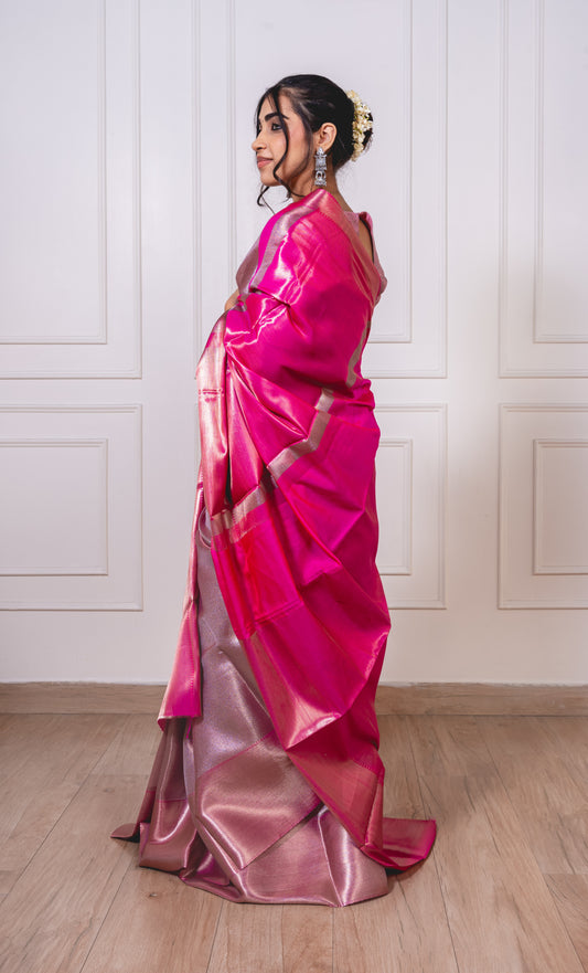 Pink tissue silk saree laid flat—featuring luminous dual-tone texture and elegant golden border.