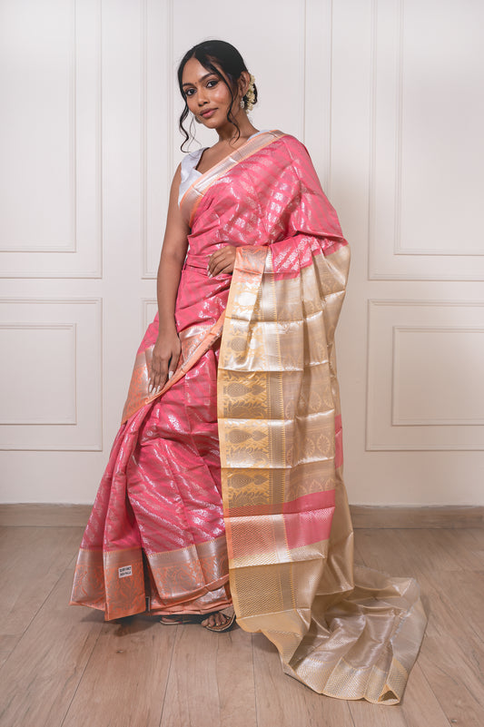 Peach semisilk saree with beige border laid flat—showcasing soft texture and intricate silver zari weaving.