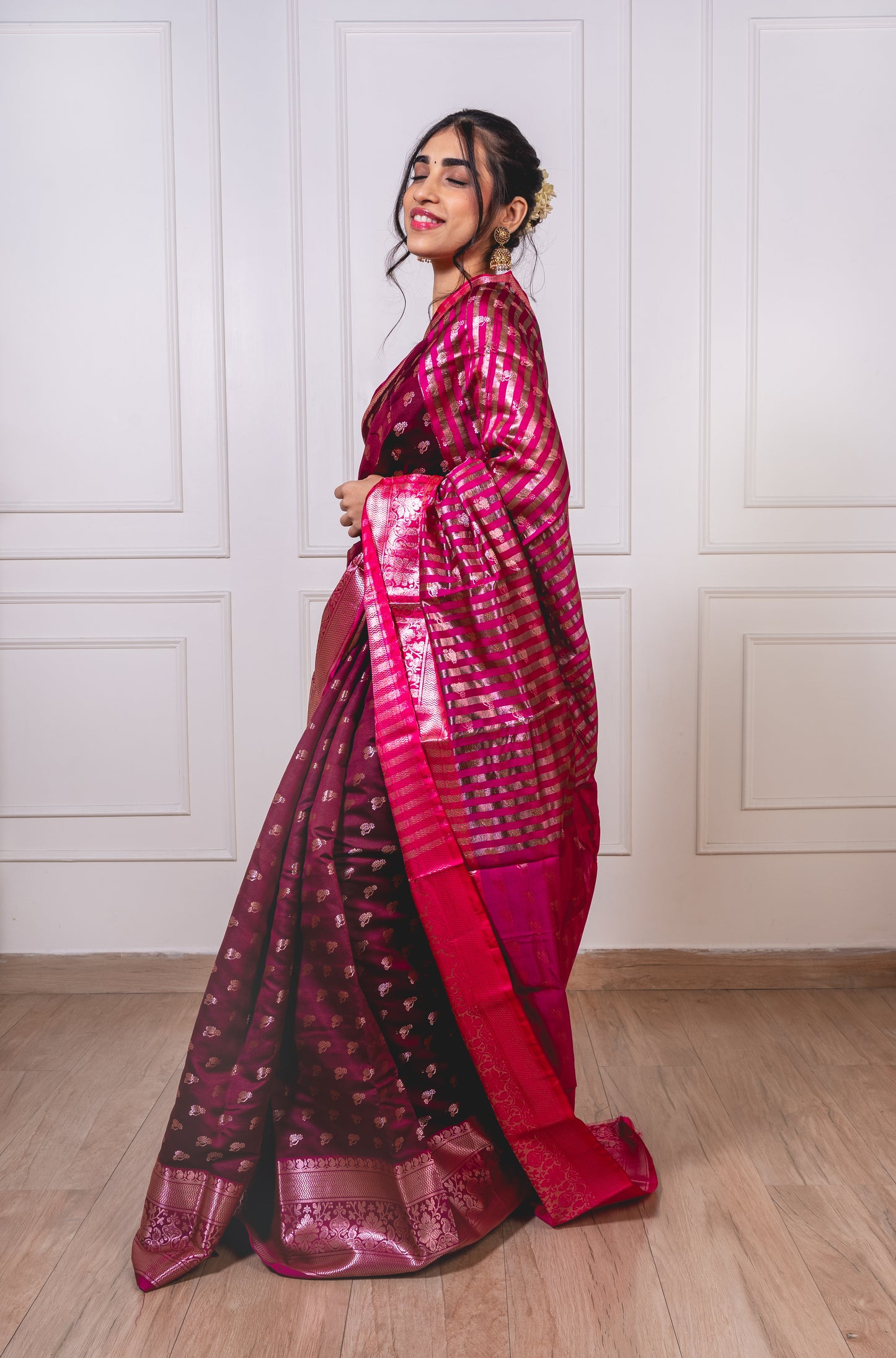 Woman wearing soft semisilk saree with woven Reshim Nath butta and broad Reshim border—styled for festive rituals and graceful gatherings.