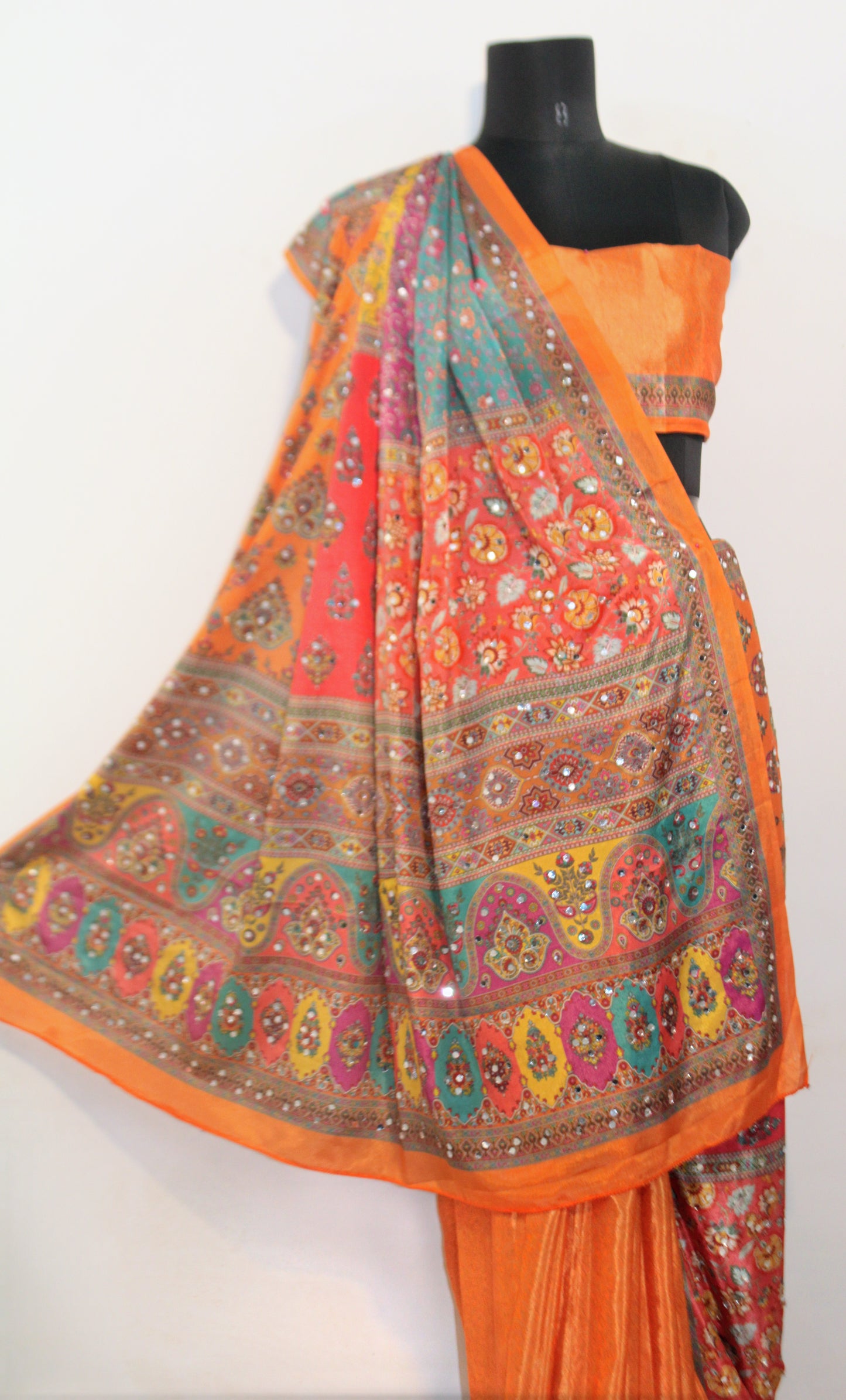 Close-up of mirror work on goldfish orange Chinon silk saree—highlighting artisanal sparkle and intricate craftsmanship.