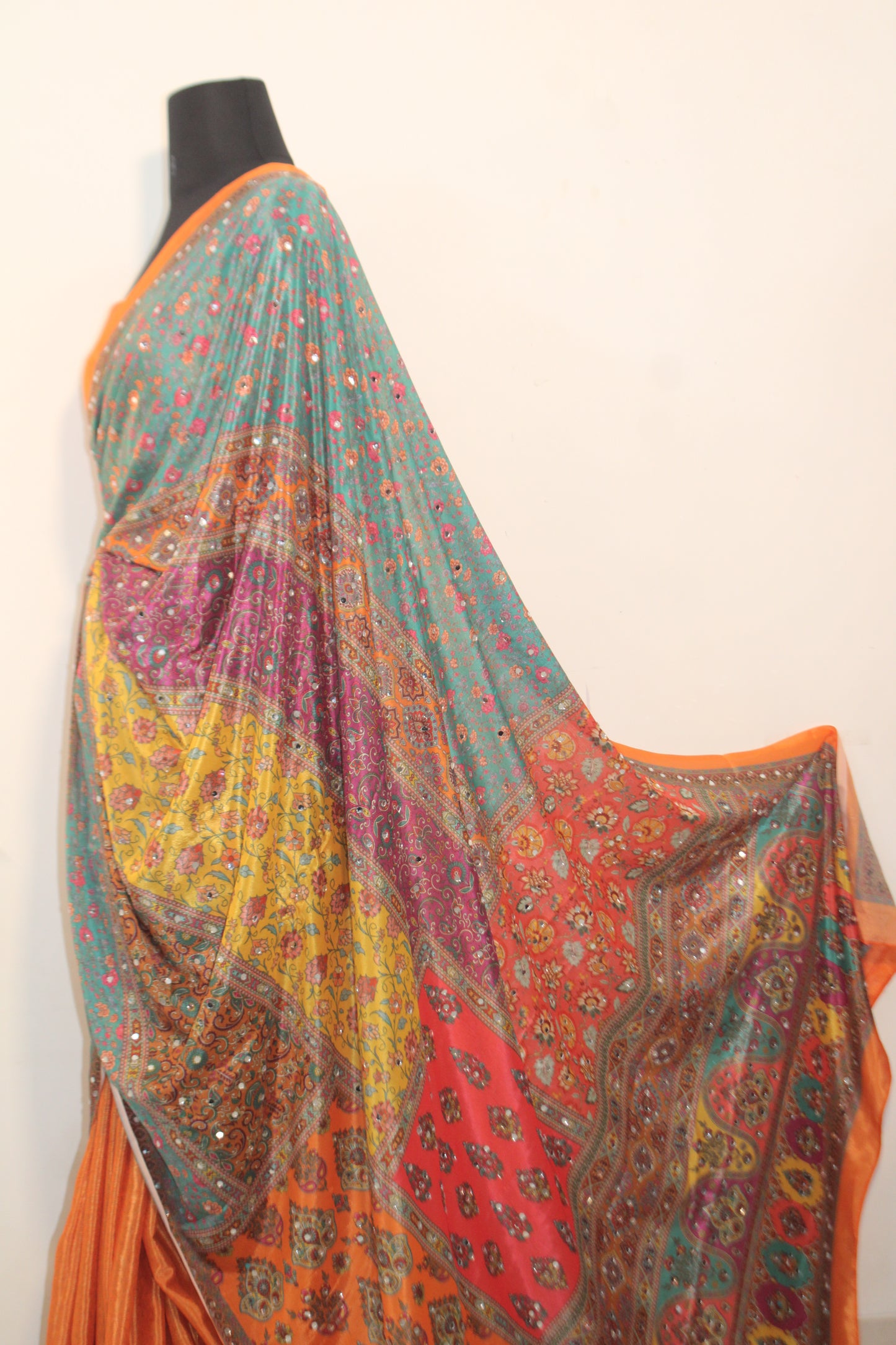 Goldfish orange Chinon silk saree laid flat—featuring shimmering mirror embellishments and soft, flowy texture