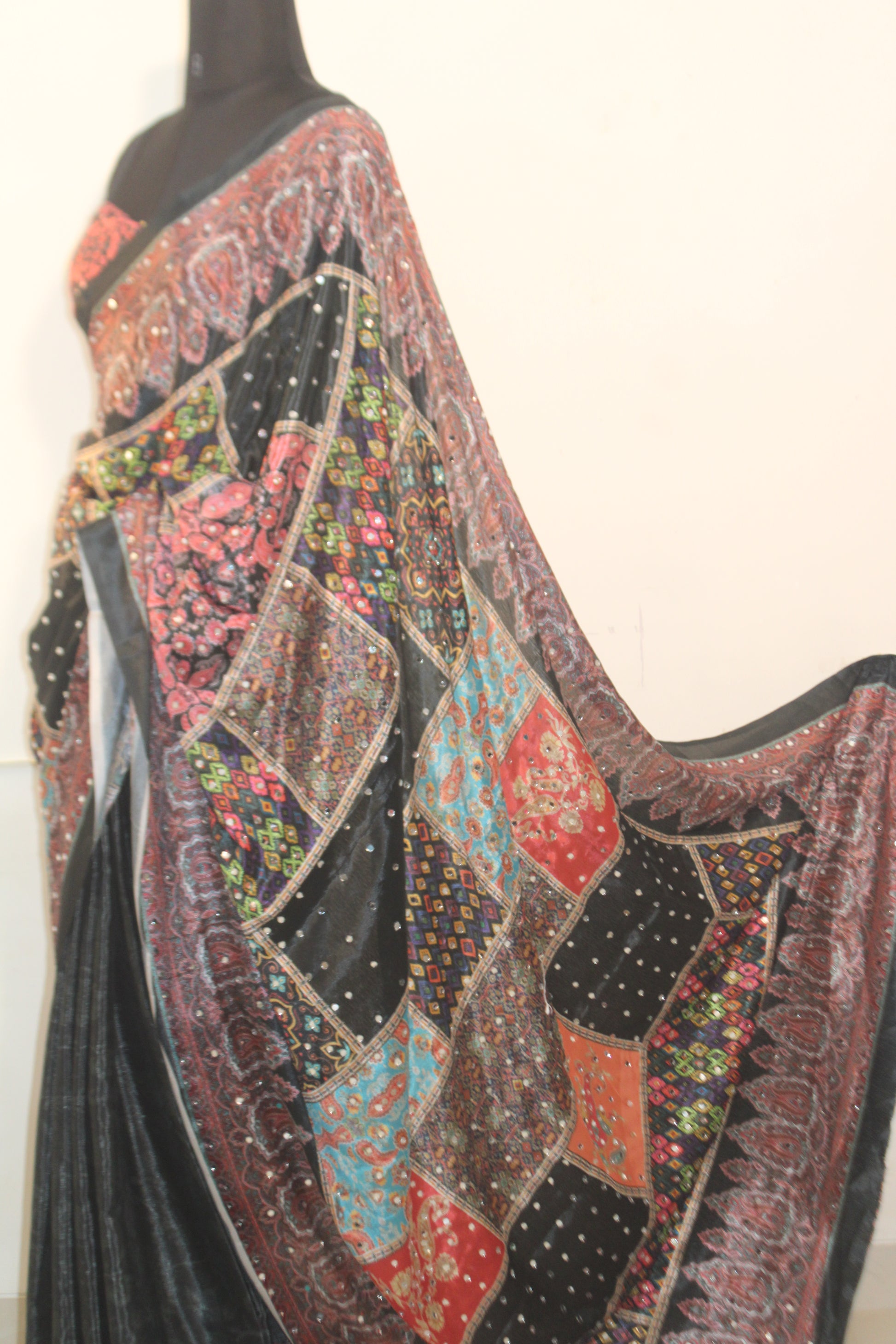 Stone black Chinon silk saree with mirror-detailed pallu and crisp pleats—capturing festive shimmer and graceful movement.