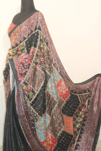 Stone black Chinon silk saree with mirror-detailed pallu and crisp pleats—capturing festive shimmer and graceful movement.