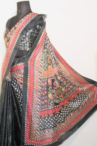 Slate black Chinon silk saree with mirror-detailed pallu and crisp pleats—capturing festive shimmer and graceful movement.