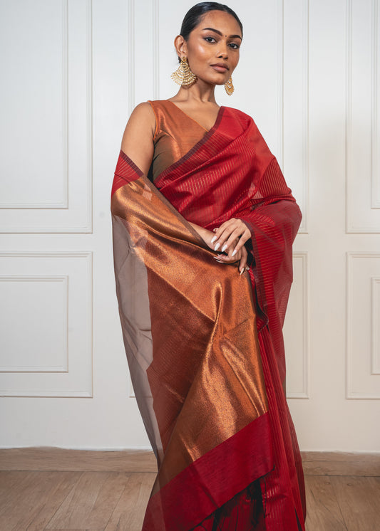 Woman wearing red Maheshwari cotton silk saree with golden zari lines and pallu—styled for festive grace and heritage charm.