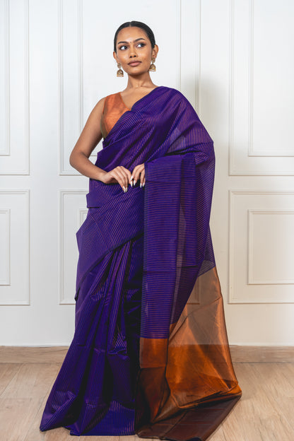 Woman wearing blue Maheshwari cotton silk saree with copper zari lines and pallu—styled for festive grace and traditional charm.