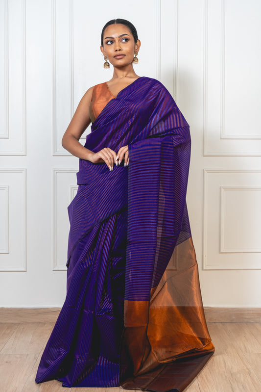 Woman wearing blue Maheshwari cotton silk saree with copper zari lines and pallu—styled for festive grace and traditional charm.
