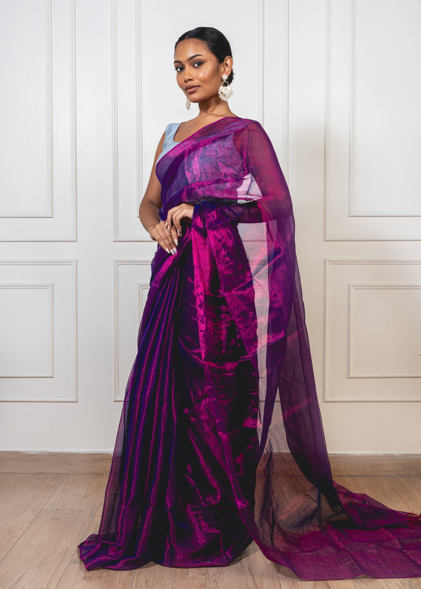 Woman wearing magenta tissue silk saree—styled for festive elegance with sheer texture and radiant movement.