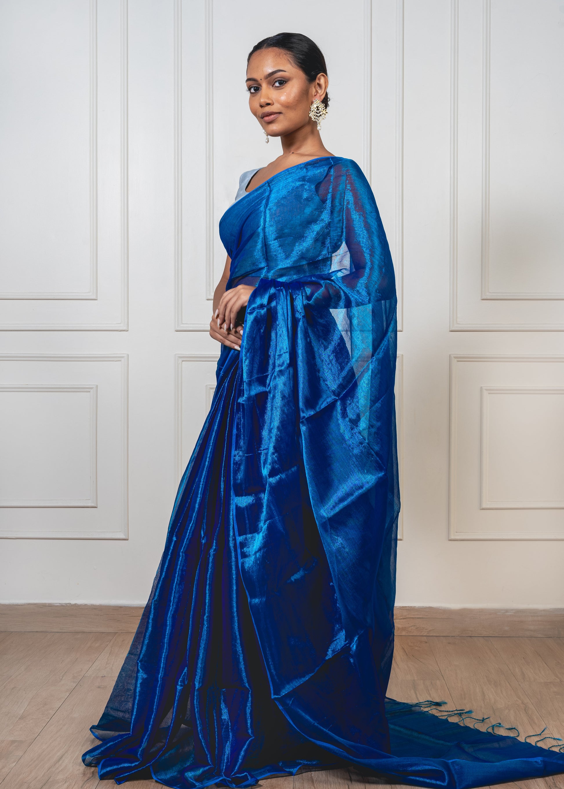 Woman wearing royal blue tissue silk saree—styled for festive evenings, graceful rituals, and timeless sophistication.
