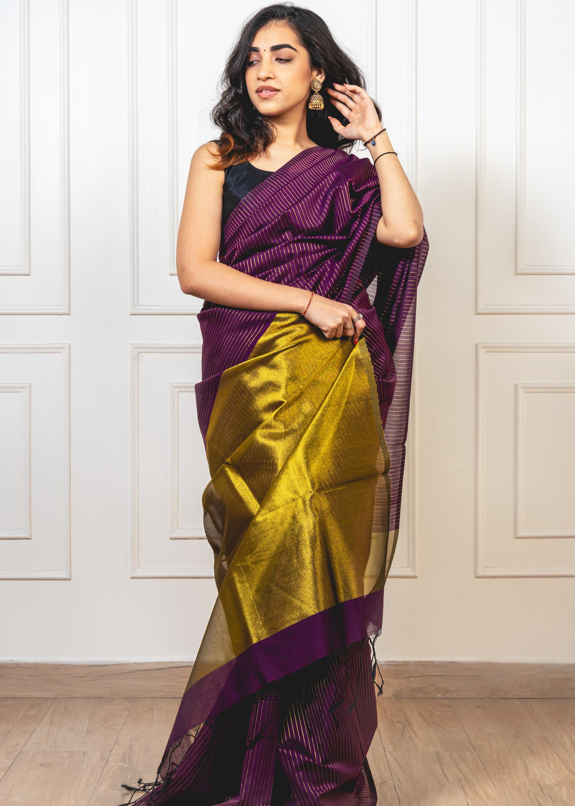 Woman wearing magenta Maheshwari cotton silk saree with Gold zari lines and pallu—styled for festive elegance and artisanal charm.