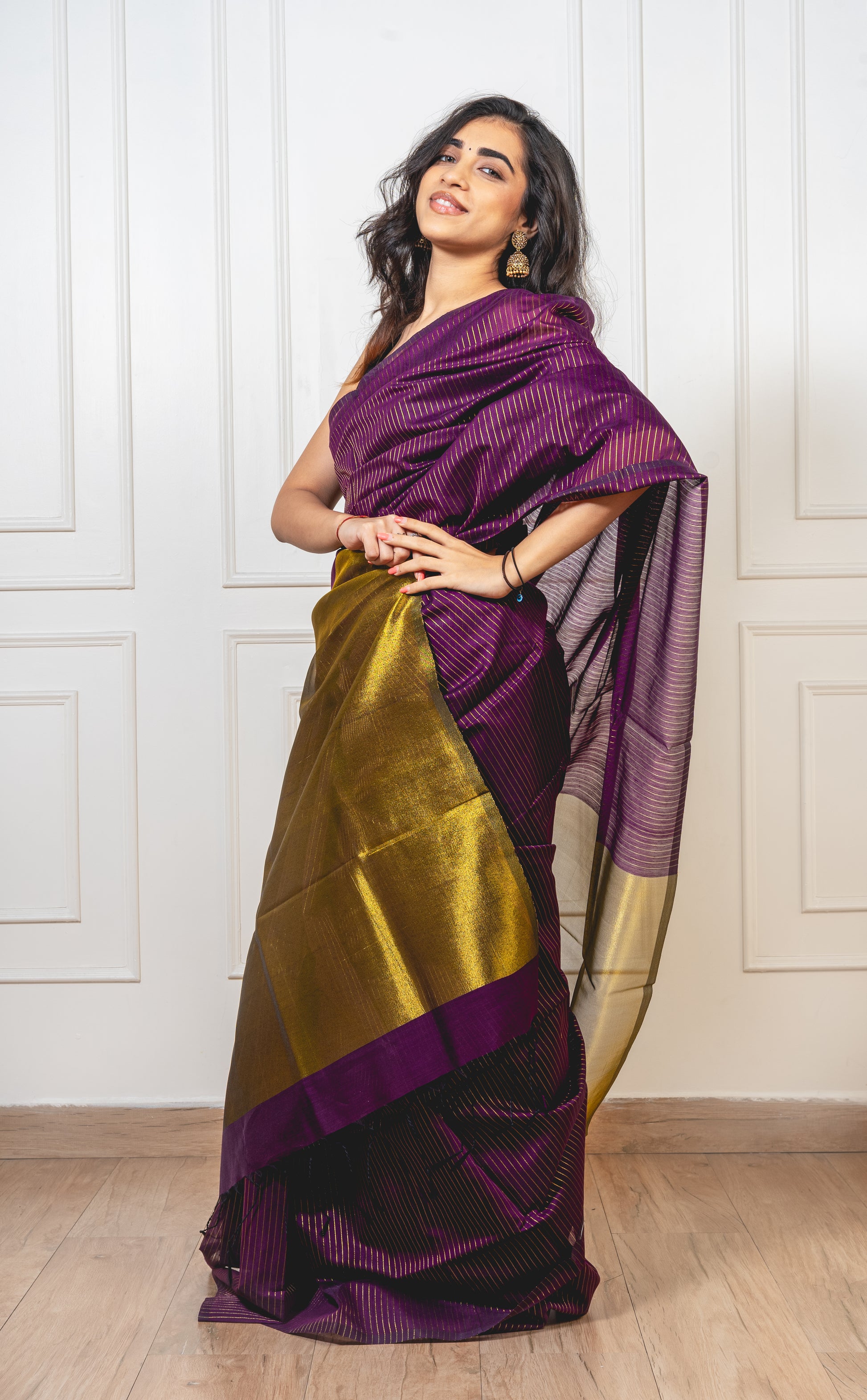 Magenta Maheshwari cotton silk saree with gold zari pallu and crisp pleats—capturing regal contrast and woven finesse