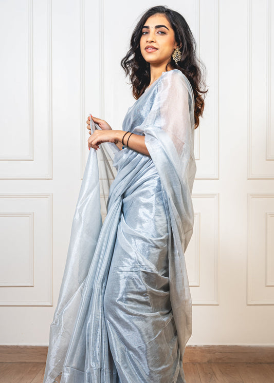 Woman wearing moonlight silver tissue silk saree—styled for festive evenings, receptions, and graceful celebrations.