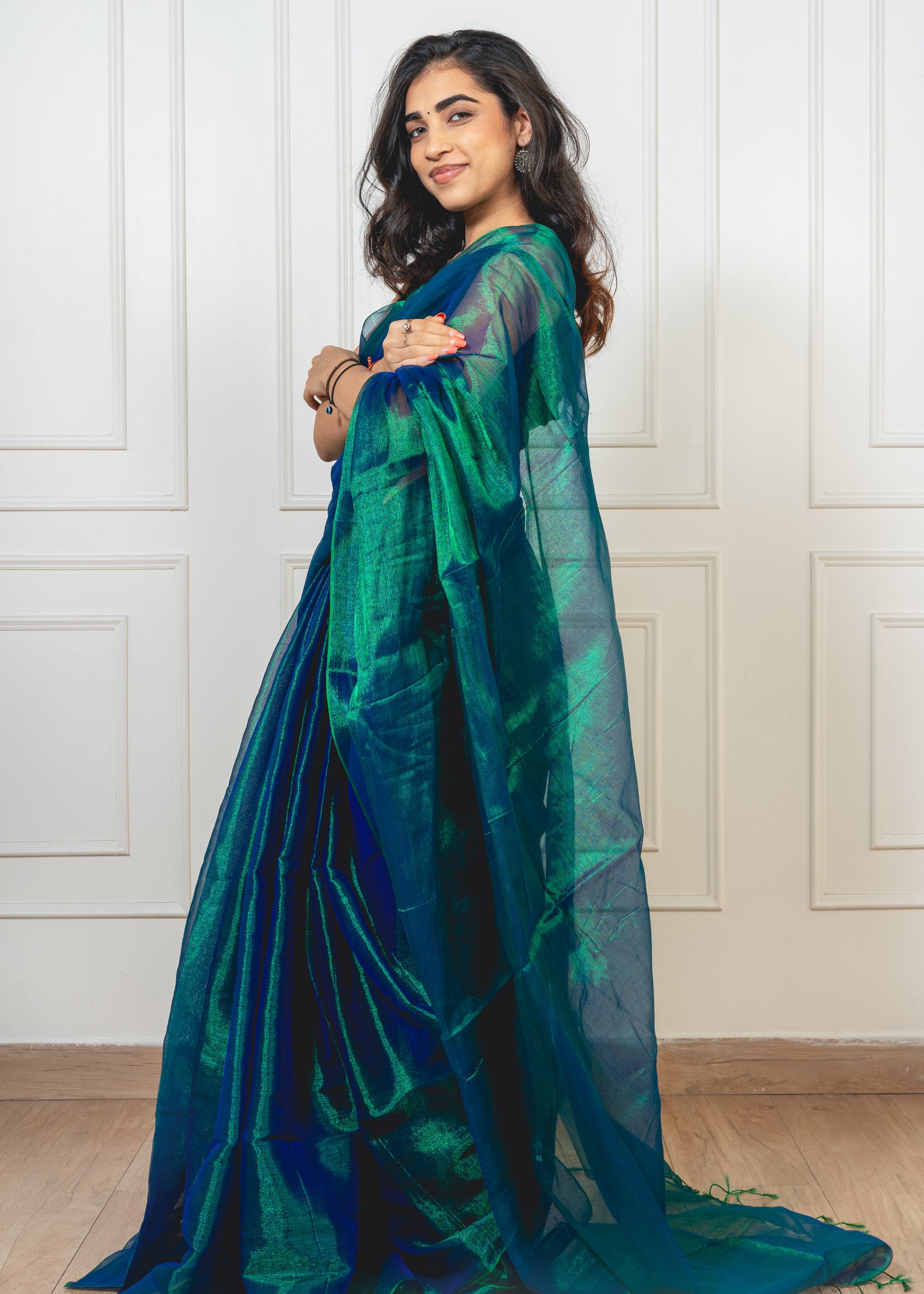 Peacock green tissue silk saree with flowing pallu and uninterrupted finish—evoking twilight shimmer and effortless sophistication
