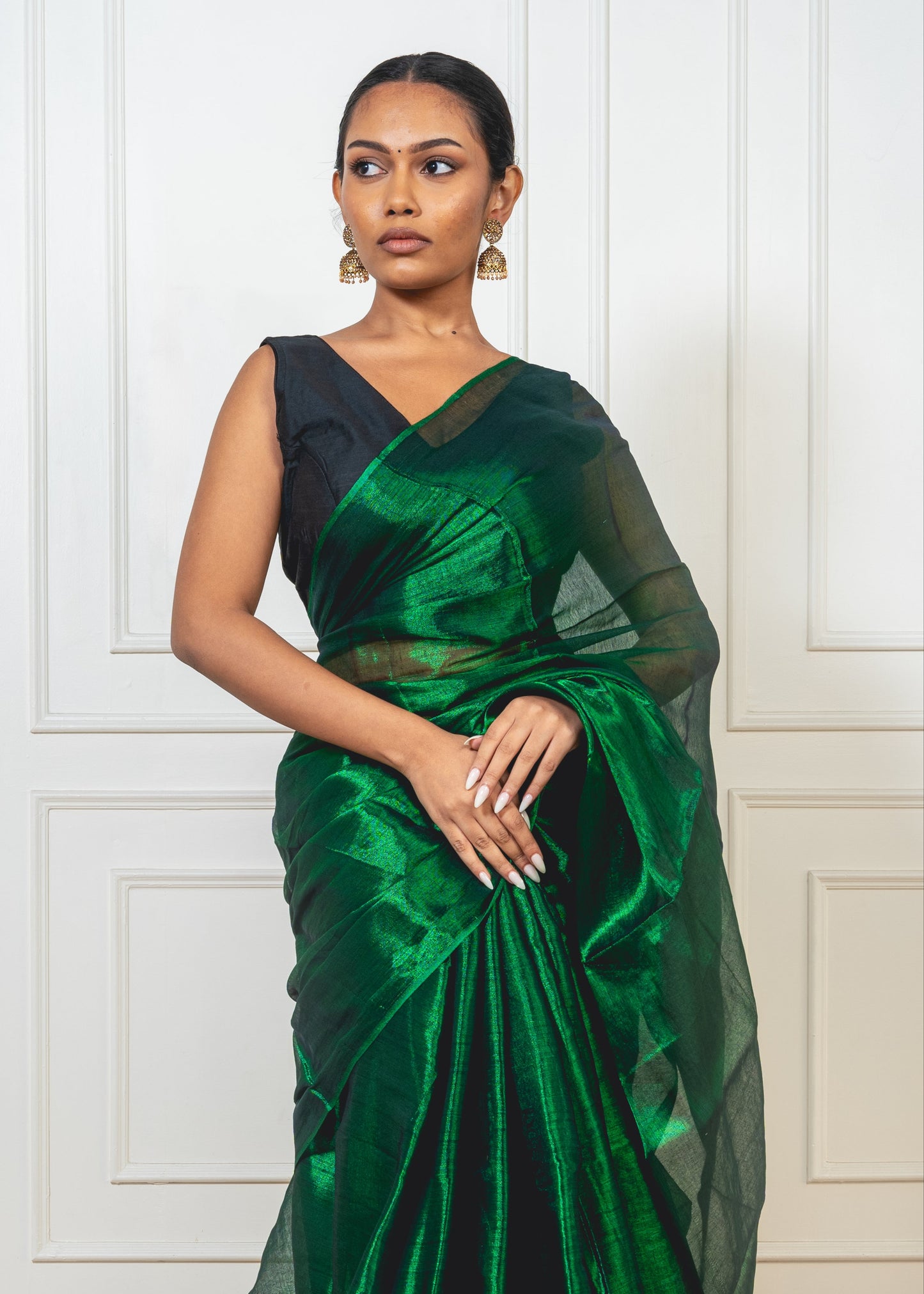 Close-up of emerald green tissue silk saree—showcasing shimmer, fine weave, and luxurious texture.