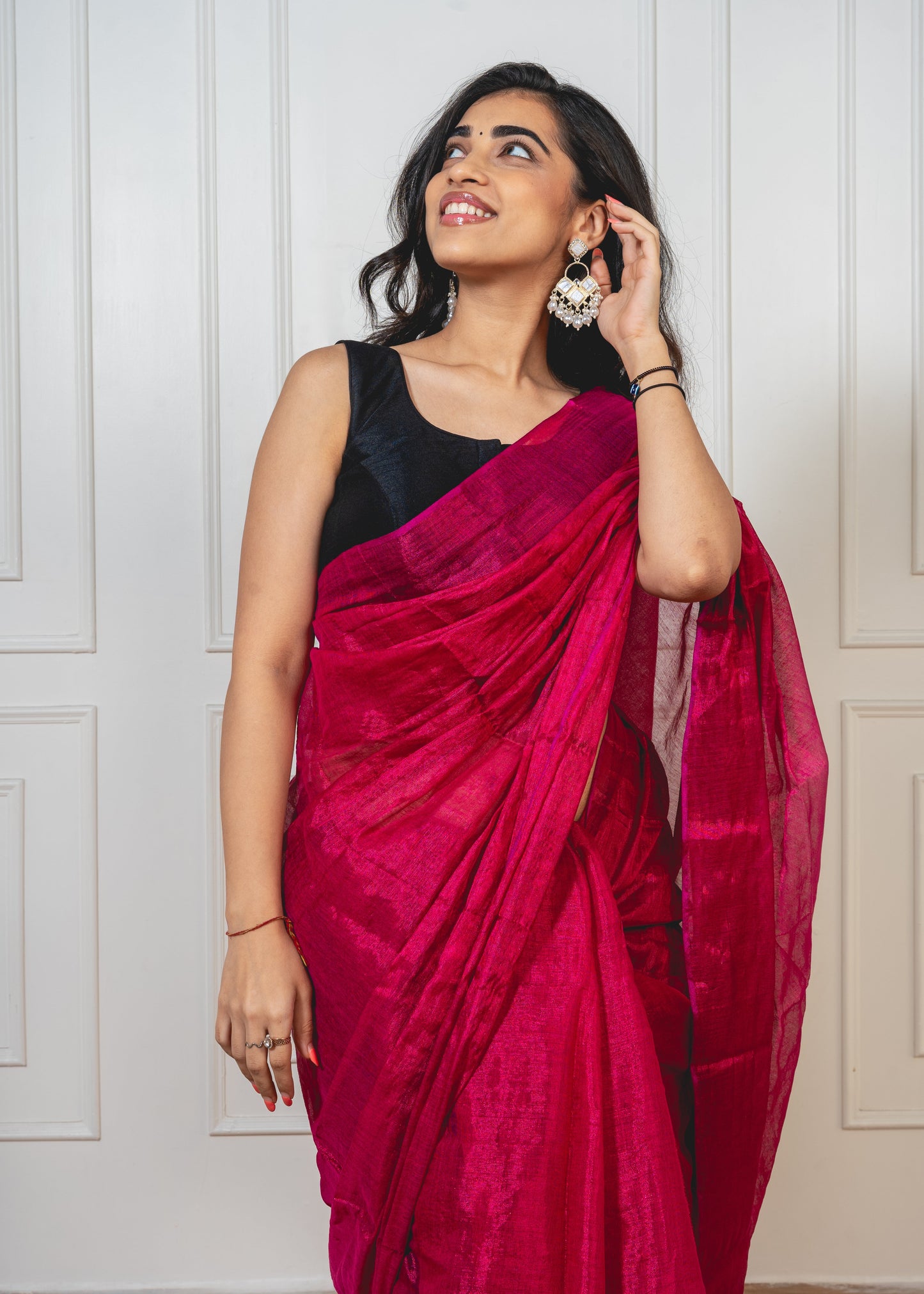 Close-up of cherry red tissue silk saree—showcasing shimmer, fine weave, and luxurious texture.