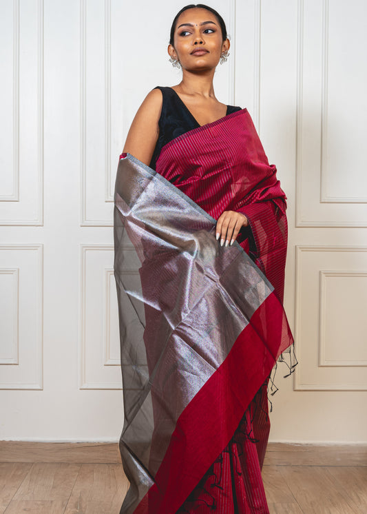 Woman wearing magenta Maheshwari cotton silk saree with silver zari lines and pallu—styled for festive grace and artisanal charm.