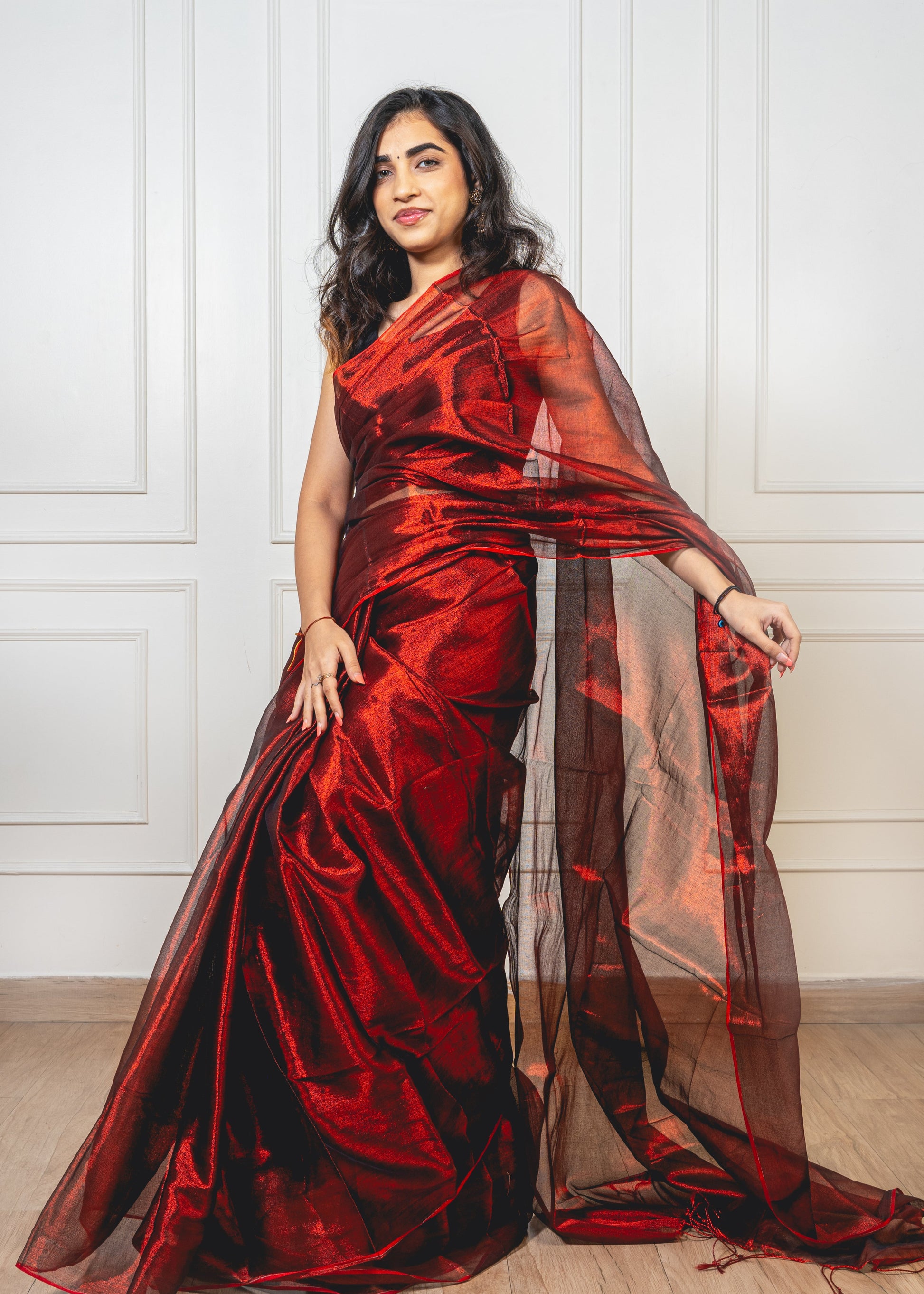 Royal maroon tissue silk saree with flowing pallu and radiant finish—evoking regal charm and timeless elegance.