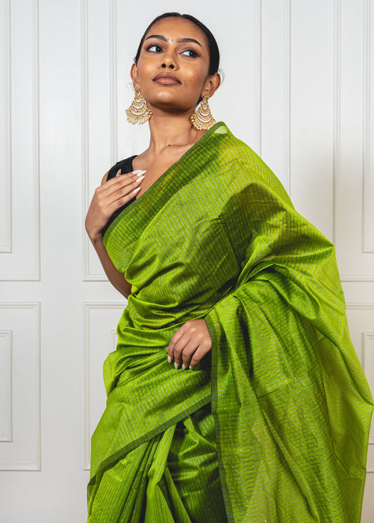 Woman wearing light green Maheshwari cotton silk saree with silver zari lines and pallu—styled for festive grace and artisanal charm.