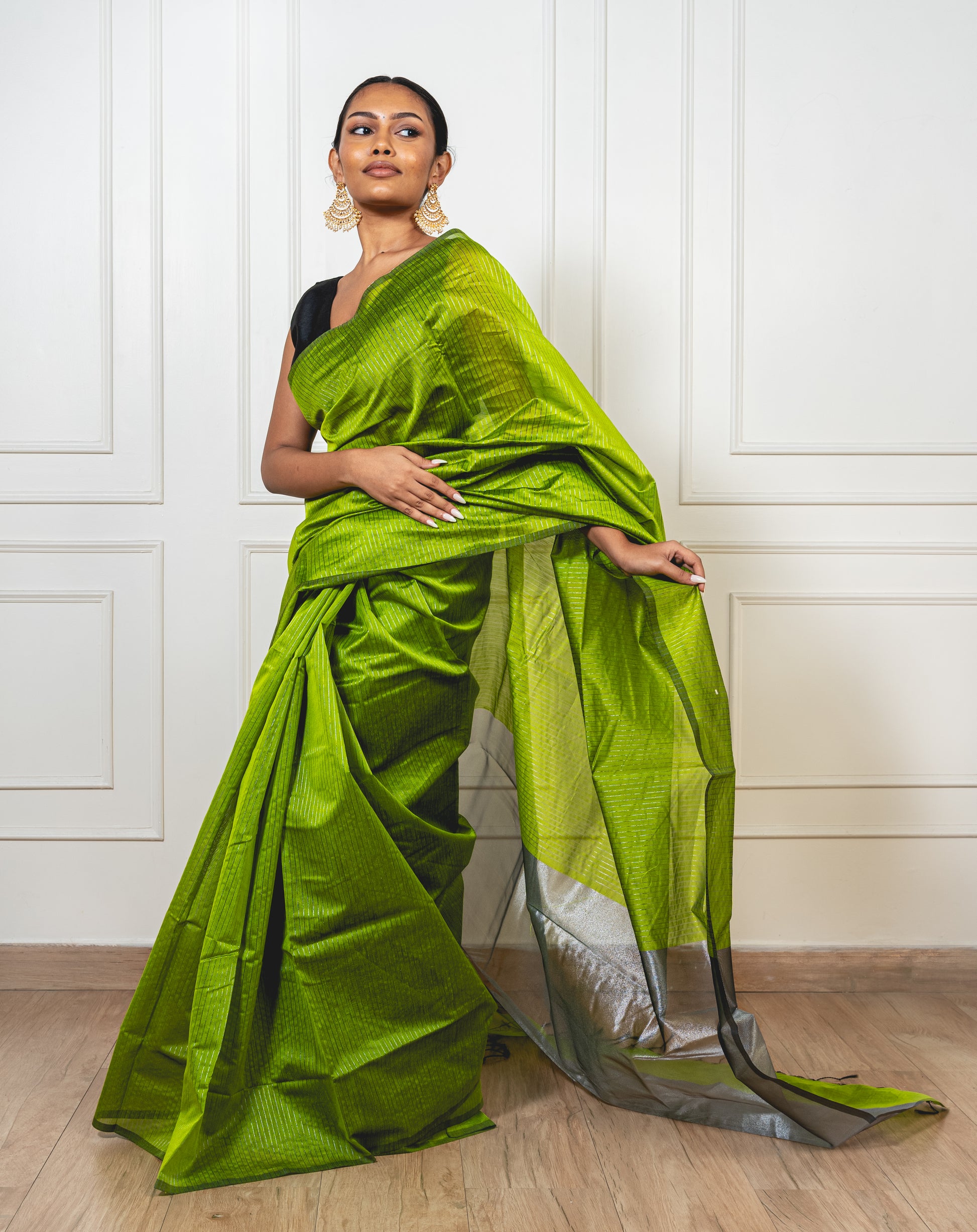 Light green Maheshwari cotton silk saree with Silver zari pallu and crisp pleats—capturing pastel elegance and woven finesse