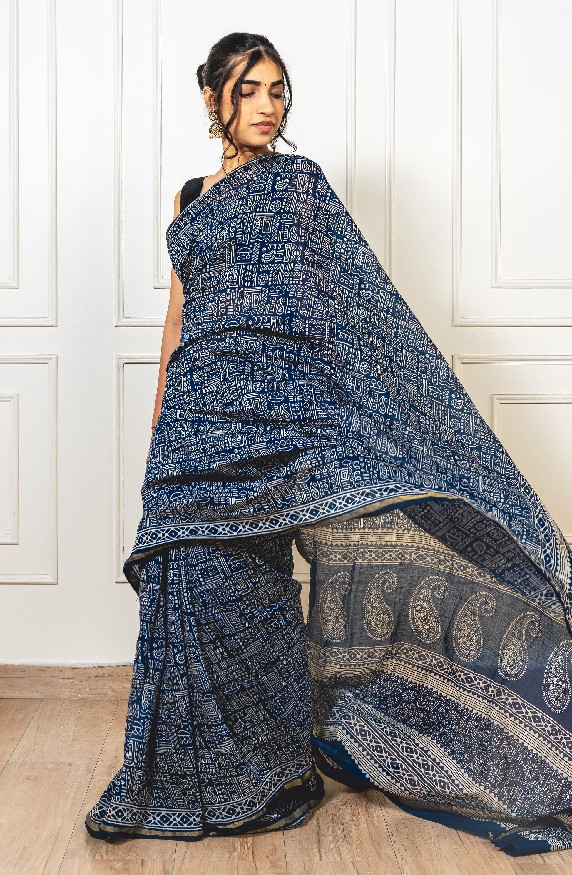 Woman wearing blue Chanderi cotton saree with Warli print—styled for festive grace and cultural charm.