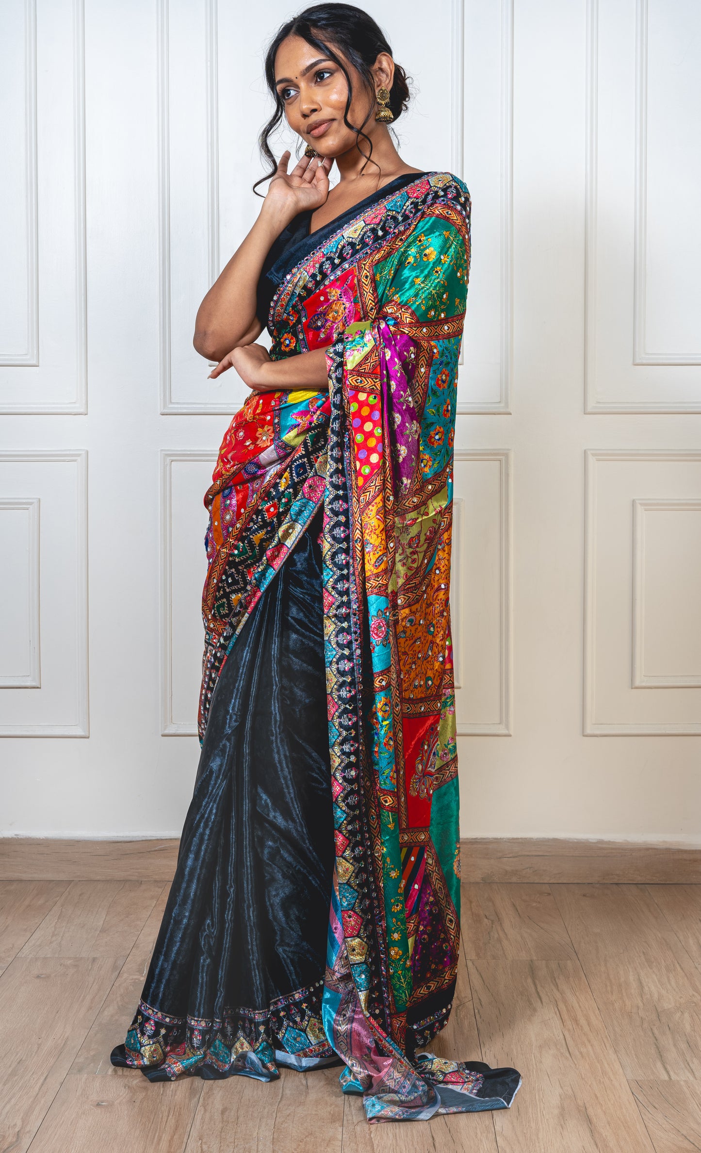 Raven black Chinon silk saree with mirror-detailed pallu and crisp pleats—capturing festive shimmer and graceful movement.