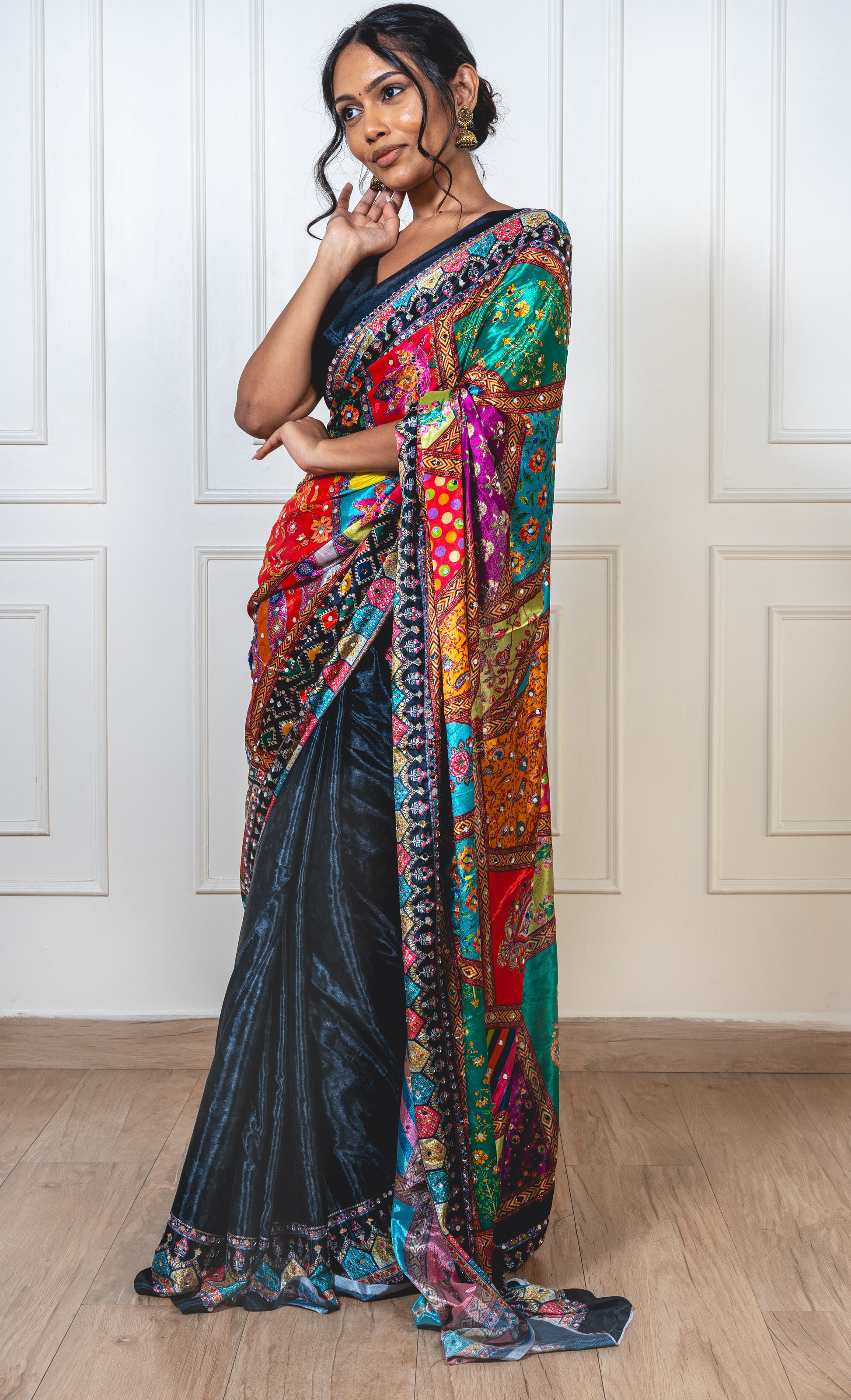 Raven black Chinon silk saree with mirror-detailed pallu and crisp pleats—capturing festive shimmer and graceful movement.