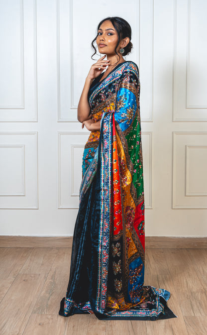 Woman wearing charcoal black Chinon silk saree with mirror work—styled for Navaratri garba nights and festive elegance.