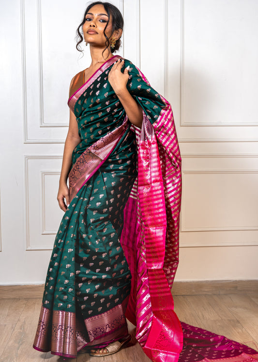Woman wearing peacock green saree with golden zari and red border—styled for festive rituals, weddings, and traditional celebrations.