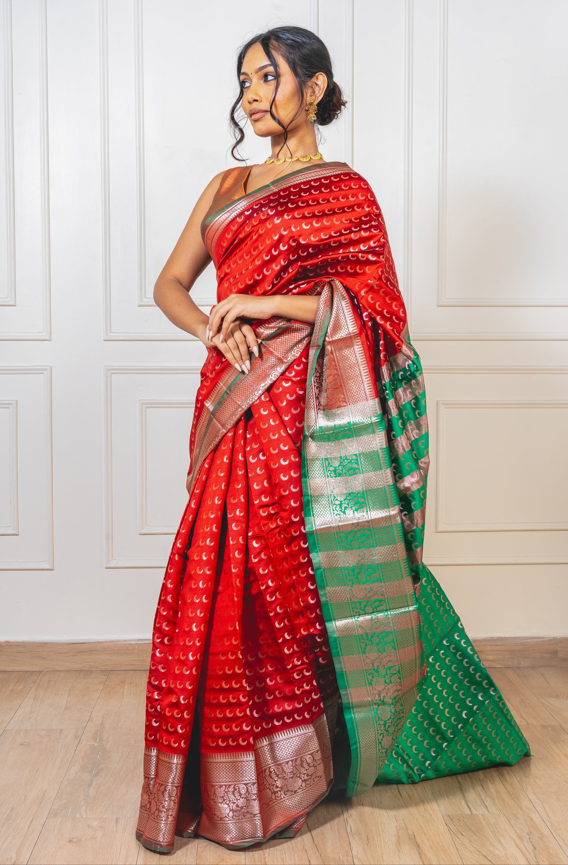 Red Chandrakor Butta saree with crescent motifs on pallu and pleats—capturing festive richness and graceful movement.