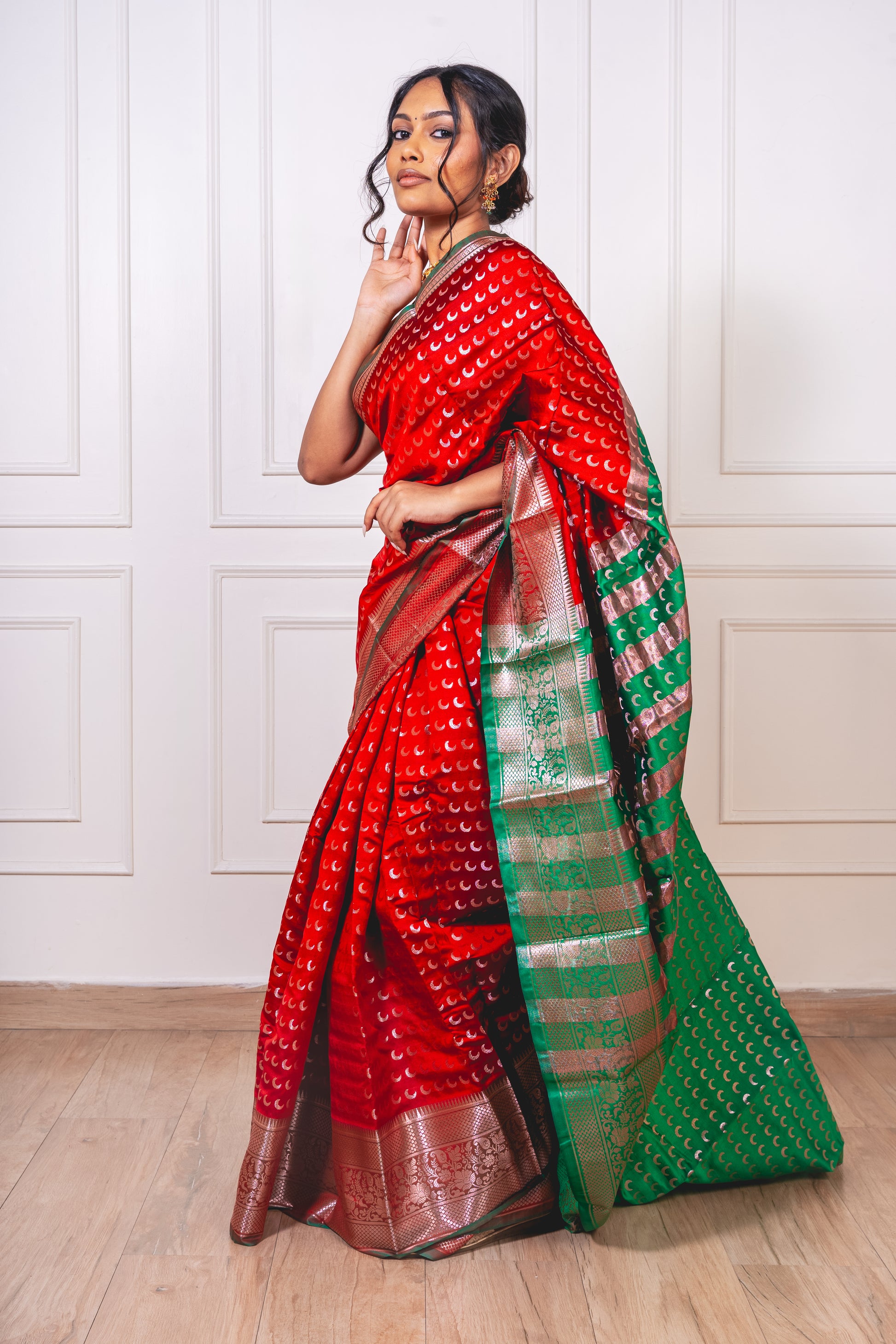 Red Chandrakor Butta saree laid flat, showcasing crescent-inspired weaves and rich texture—crafted for timeless celebration.