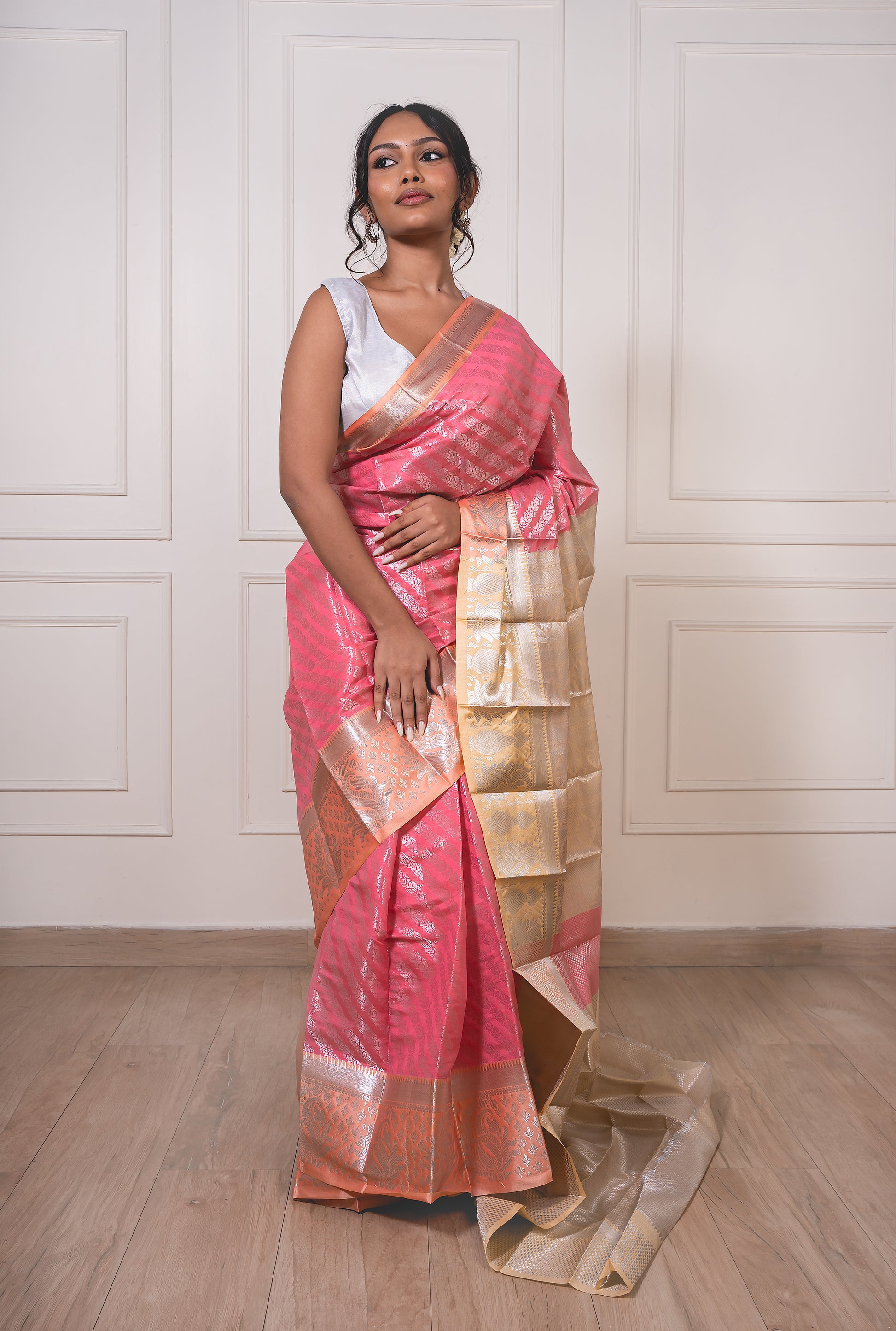 Peach semisilk saree with flowing pallu, beige border, and silver zari—evoking heirloom charm and understated sophistication.