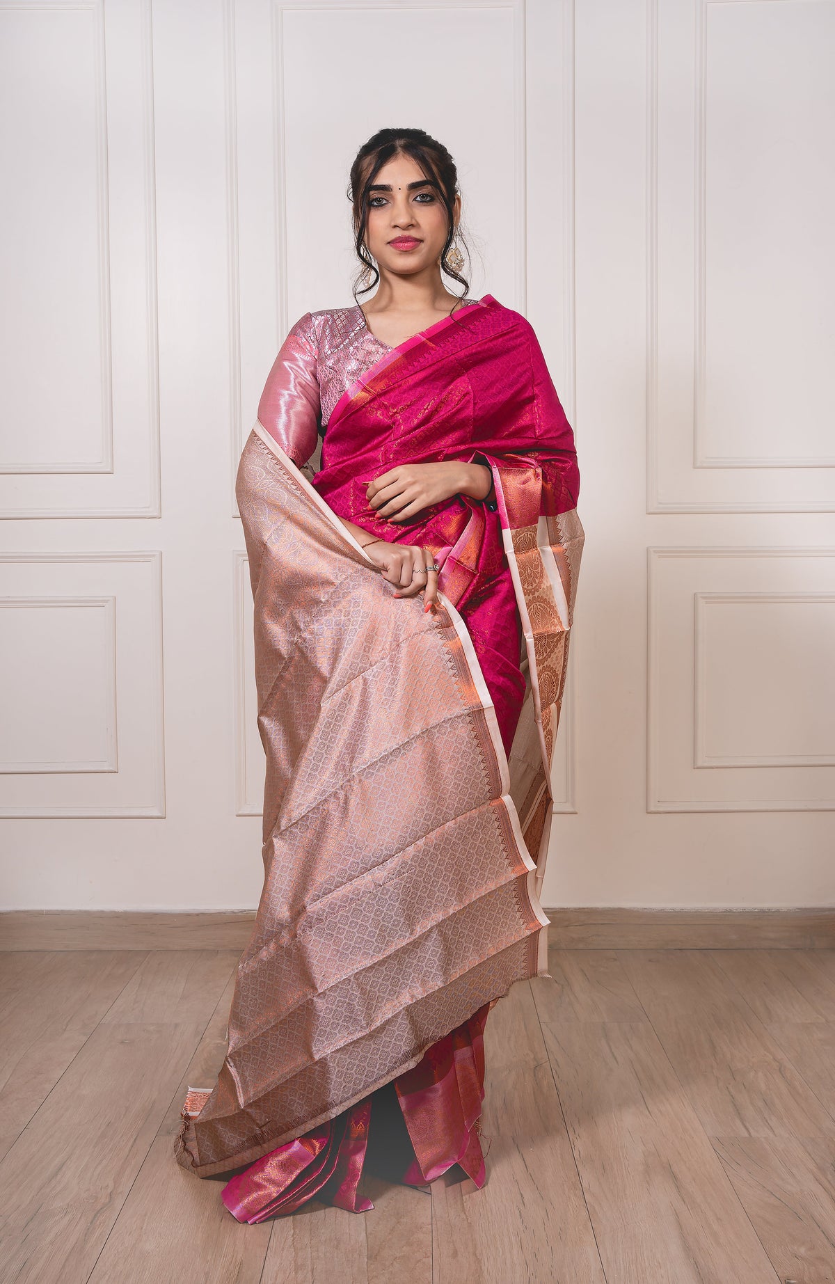 Woman wearing dark pink semi-silk saree with light pink border and copper zari—styled for festive elegance and graceful movement.