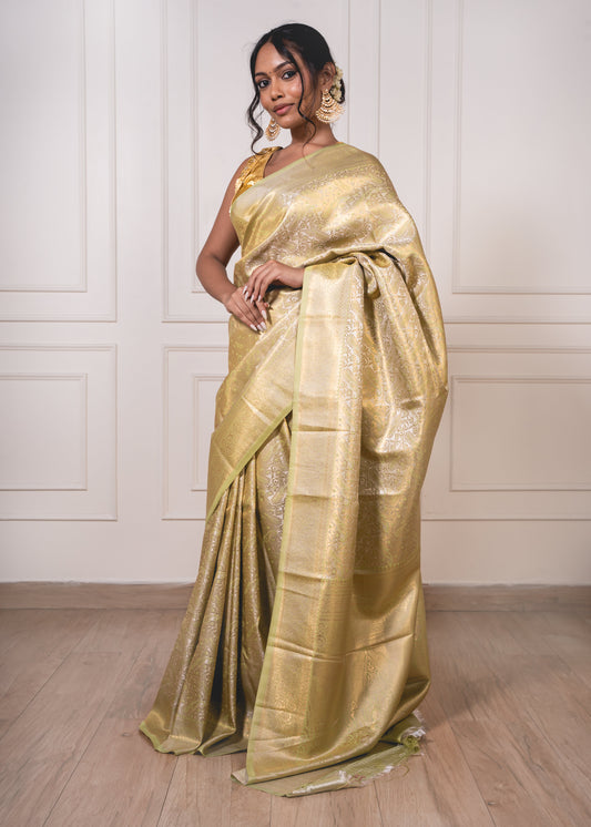 Woman wearing light green litchi silk saree with golden jacquard weave—styled for graceful movement and festive elegance.