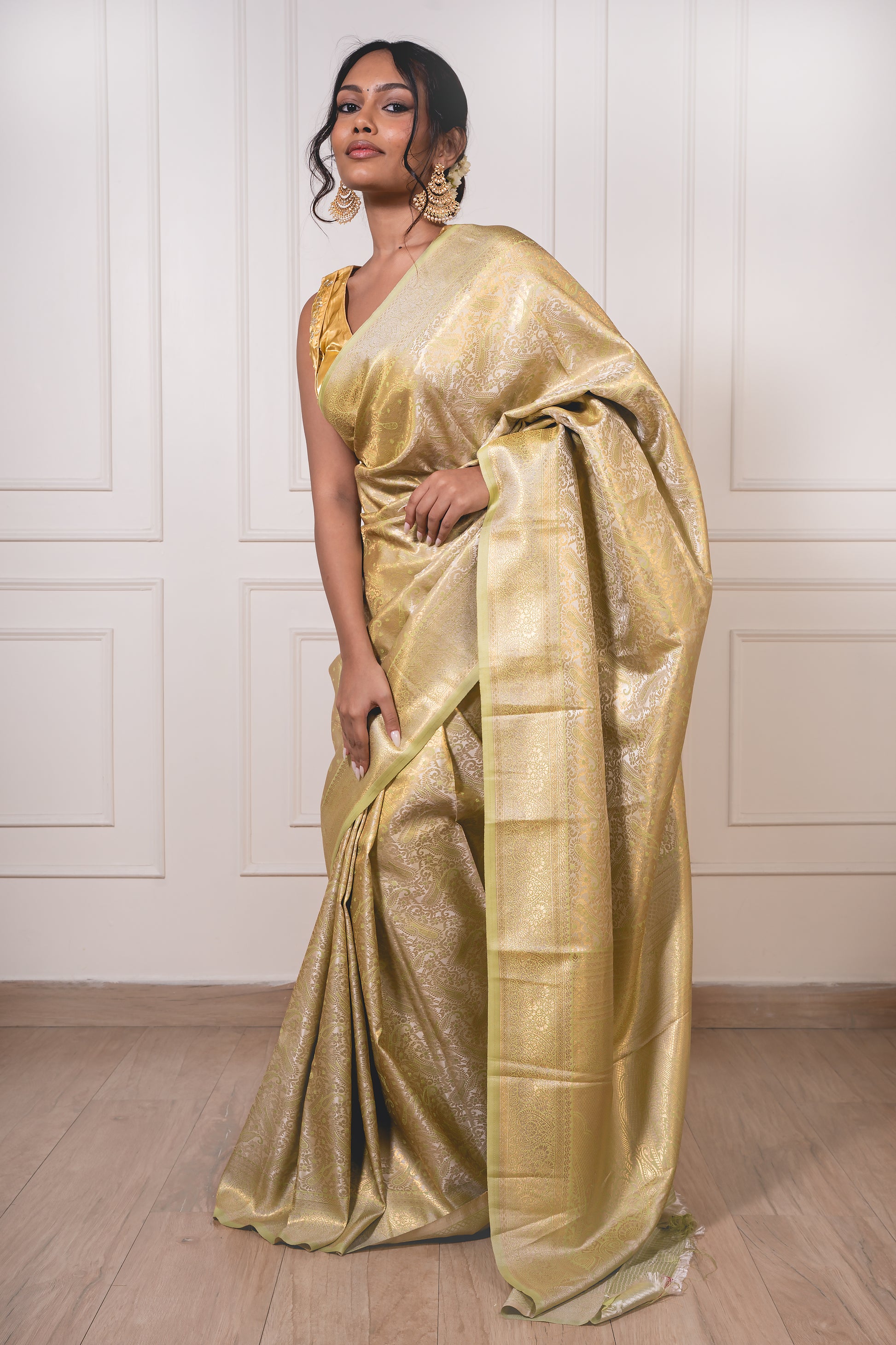 Light green litchi silk saree with golden jacquard pallu and crisp pleats—capturing heirloom charm and celebratory glow.