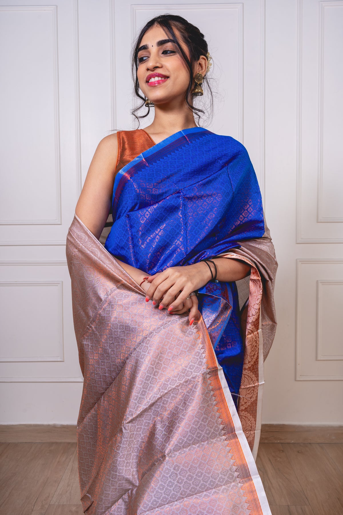 - Royal blue semisilk saree with flowing pallu, white border, and copper zari—evoking heirloom charm and twilight elegance.