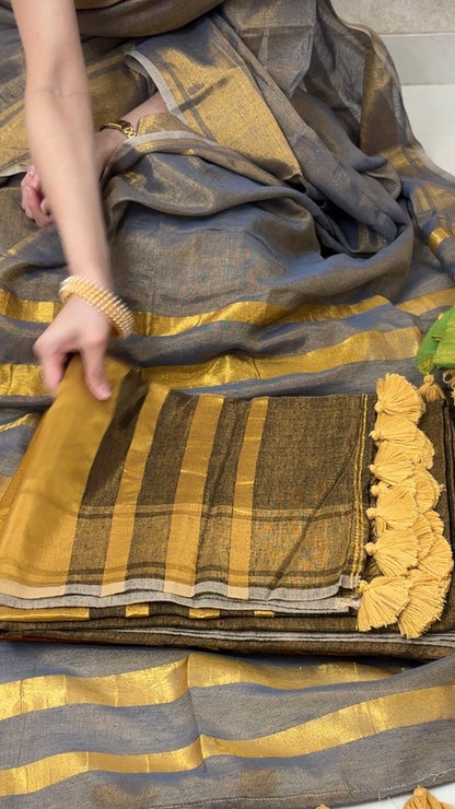 Woman displaying Brown Khadi Tissue Saree in golden tones, exuding festive elegance and grace