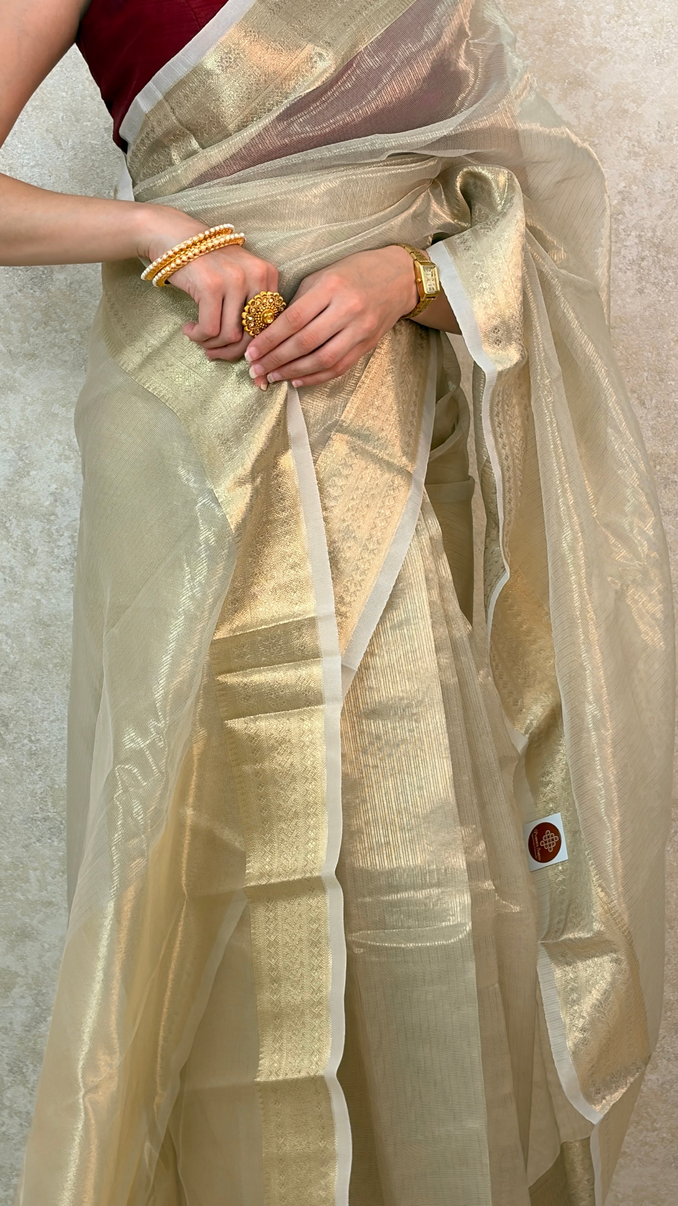 Female model showcasing Banaras Weave on luminous Golden Tissue Saree