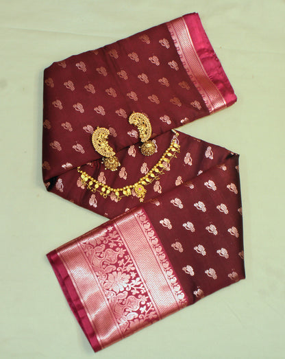 Close-up of golden zari on maroon semi silk saree—highlighting dramatic contrast and fine craftsmanship