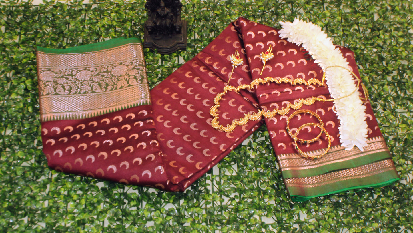 Maroon Chandrakor Butta saree laid flat, showcasing intricate crescent weaves and deep ceremonial tone.