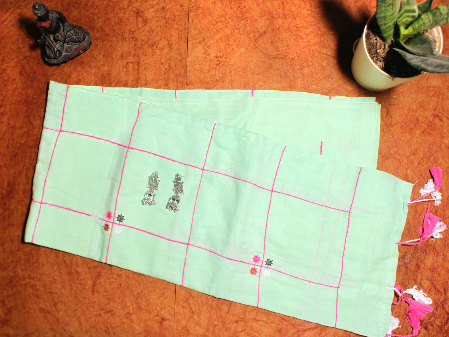 Close-up of pastel checks on green cotton saree—highlighting soft contrast and woven detail.