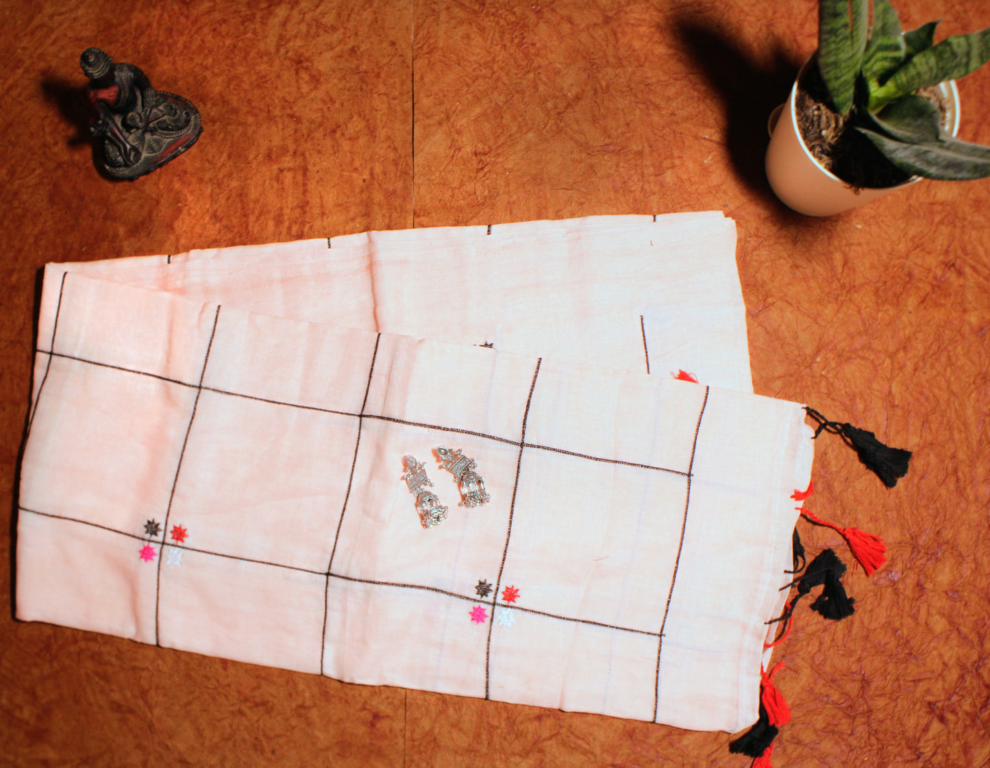 Close-up of pastel checks on peach cotton saree—highlighting delicate tones and graceful pattern.