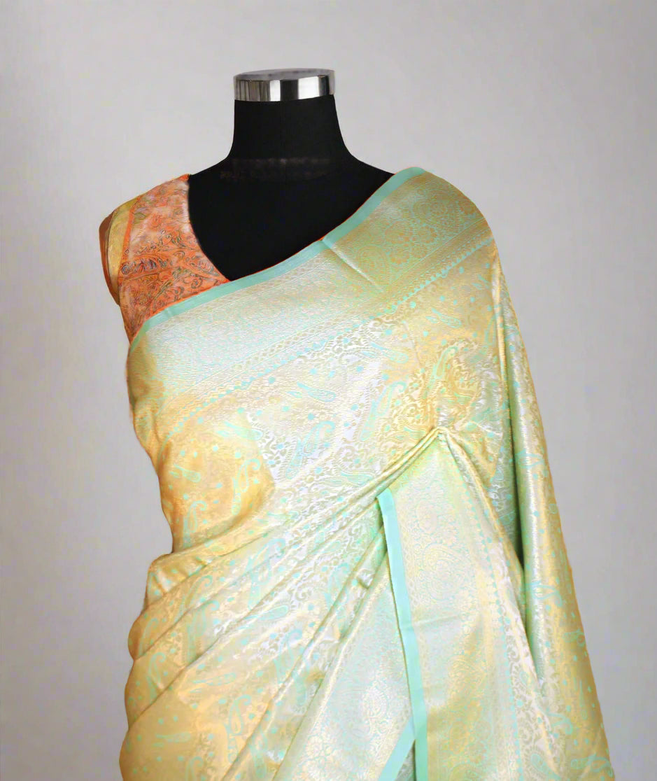 Close-up of golden zari on firozi litchi silk saree—showcasing intricate craftsmanship and shimmering finesse