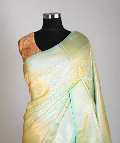 Close-up of golden zari on firozi litchi silk saree—showcasing intricate craftsmanship and shimmering finesse