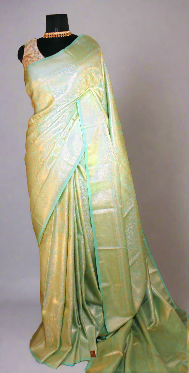 Maniqueen wearing firozi litchi silk saree with golden zari—styled for regal elegance and festive grandeur.