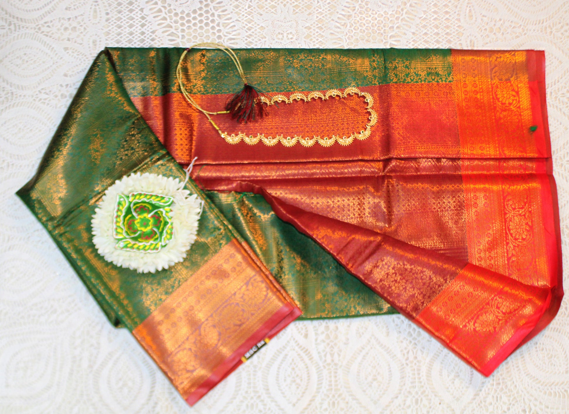 Close-up of golden zari on dark green semi silk saree—highlighting intricate craftsmanship and regal shimmer.